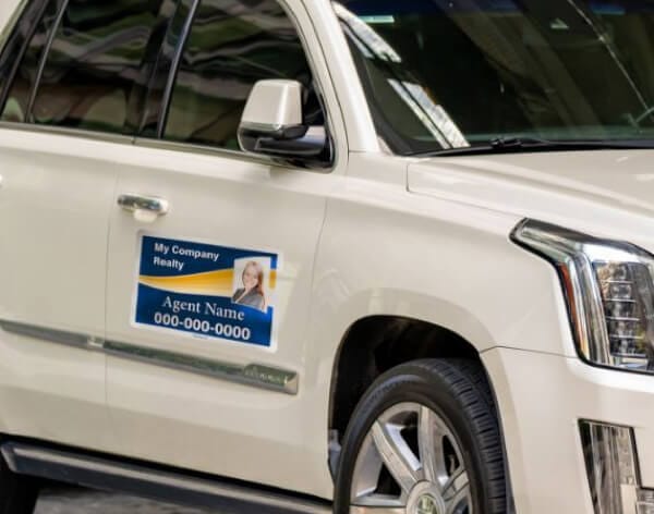 Real estate agent's car with company sign on the door