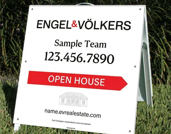 Engel and Volkers open house A-frame real estate sign on grass.