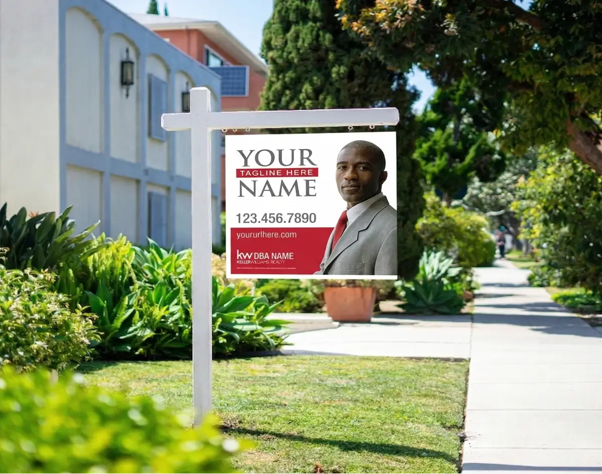 Keller Williams real estate yard sign in white and red featuring an agent photo and contact information on a white post