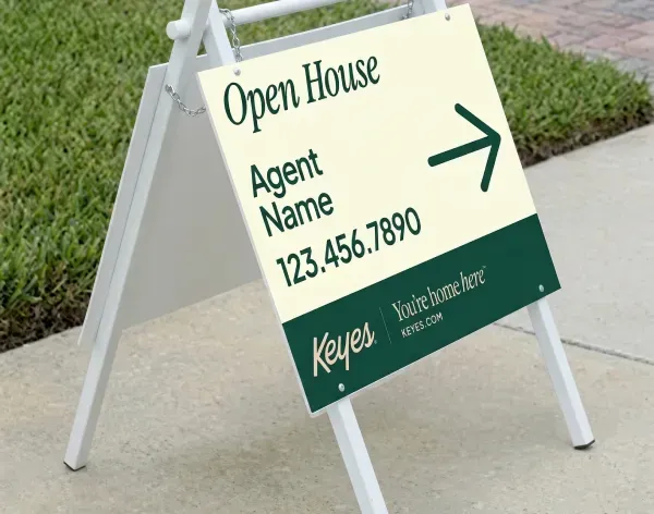Keyes Realty open house A-frame directional sign on sidewalk.