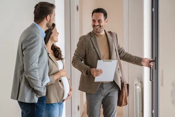 Real estate agent showing a couple a home, showcasing client engagement strategies.