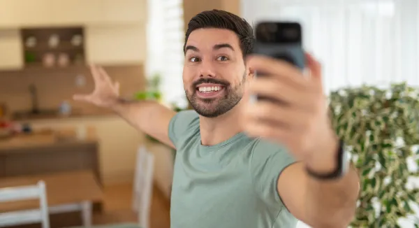 Man filming a selfie-style video inside a home to promote a real estate listing.
